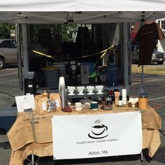 an outdoor coffee stand with various items on it