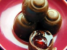 three chocolate candies on a plate with syrup