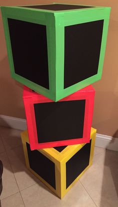 three different colored blocks stacked on top of each other in the middle of a room