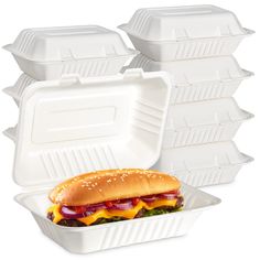 a white takeout container filled with a large sandwich and six smaller ones behind it