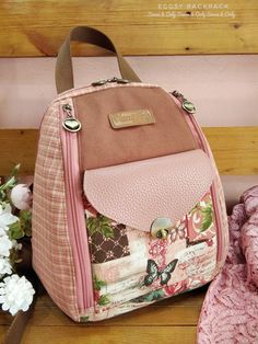 a pink backpack sitting on top of a wooden floor next to flowers and a stuffed animal