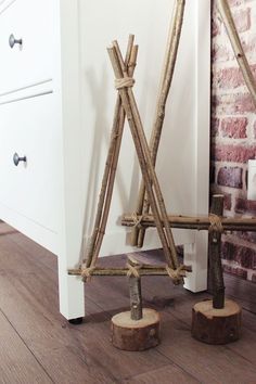 a pair of wooden poles sitting on top of a floor next to a brick wall