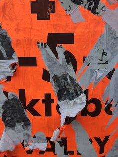 an orange and black collage with torn up pieces of paper on top of it