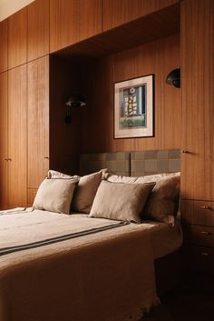 a bed sitting in a bedroom next to a wooden paneled wall with pictures on it