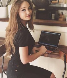 a woman sitting at a desk with a laptop