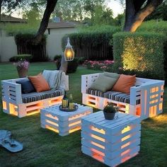 outdoor furniture made out of pallets with lights on them and some plants in the background