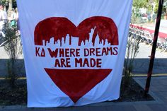 a banner with a heart and the words ka where dreams are made on it in front of a cityscape