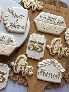 decorated cookies are on a wooden board with white and gold lettering that says, we still do