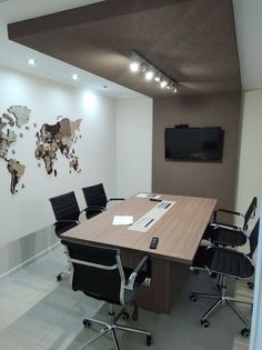 an empty conference room with black chairs and a wooden table