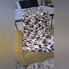 a chair with a blanket on top of it in front of a bed and couch