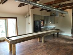 an empty kitchen and dining room with a pool table in the middle of the room