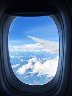 an airplane window looking out at the clouds