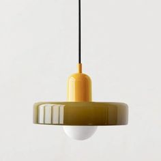 a yellow and white pendant light hanging from a ceiling fixture with black cord in the middle