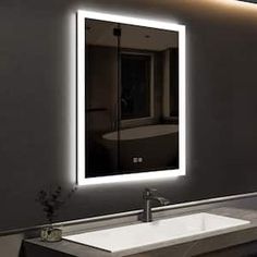 a bathroom sink under a large mirror with lights