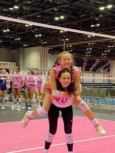 two girls in pink shirts and black pants are doing tricks on a pink court while others watch from the sidelines