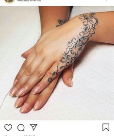 two hands holding each other with tattoos on them