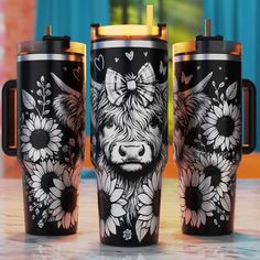 three travel mugs decorated with cows and sunflowers