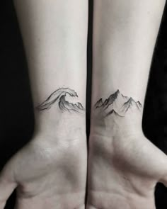 two wrist tattoos with mountains on each side and waves in the middle, one behind the other