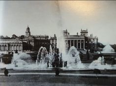 an old black and white photo of people in front of a building with water fountains