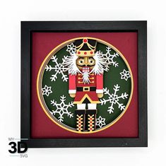 a wooden nutcracker with snowflakes on it's face in a black frame