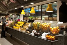 a man standing in front of a counter filled with lots of fruits and veggies