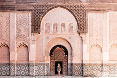 a person is standing in the doorway of an ornate building with intricately decorated walls