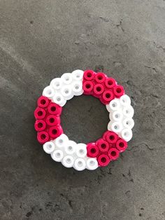 a red, white and blue wreath made out of plastic beads on the cement floor