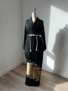 Antique black silk kurotomesode kimono with kasumi (haze) & leaf patterns. White silk lining. Partially embroidered. Kamon (family crest) on the front and back. Shown with silk obijime belt included.  Fits-like: One size fits most Length: 59"  Excellent  *Light marks on the lining.  Dry clean only Elegant Kimono With Kimono Sleeves For Tea Ceremony, Elegant Long Kimono For Tea Ceremony, Ceremonial Long Elegant Kimono, Black Long Kimono For Formal Occasions, Formal Long Black Kimono, Traditional Black Kimono For Tea Ceremony, Fitted Traditional Black Kimono, Black Samurai Kimono With Kimono Sleeves, Elegant Embroidered Silk Kimono