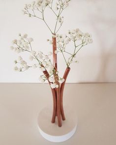 two vases with flowers in them sitting on a table