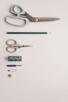 scissors, thread, and other crafting supplies laid out on a white surface