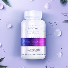 a bottle of biotin hair and skin formula on a purple background surrounded by flowers