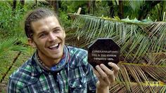 a man is holding up a plaque in front of him and smiling at the camera