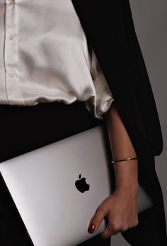 a woman holding an apple laptop in her hands