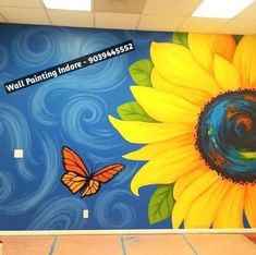 a large sunflower painted on the side of a building with a butterfly flying by