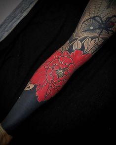 a person with a red flower tattoo on their arm