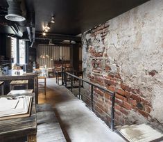 the interior of a restaurant with exposed brick walls and metal railings on either side