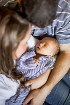 a man and woman holding a baby in their arms