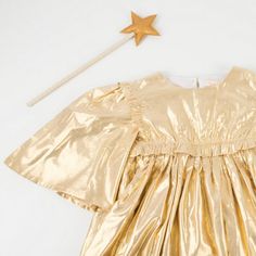 a gold dress with a star on the head and a white string attached to it