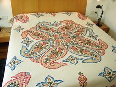 a bed with an intricately designed bedspread on it's headboard