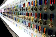 many medals are hanging on the wall in front of each other with their respective colors