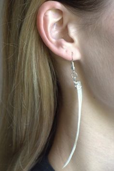 a close up of a person wearing some kind of earring on their left ear