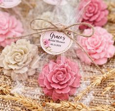 some pink and white flowers are tied up on a piece of burlock with twine