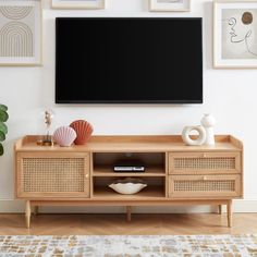 a flat screen tv mounted to the side of a wooden entertainment center in a living room