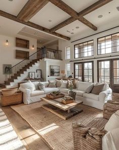 a living room filled with lots of furniture next to a stair case in front of a window