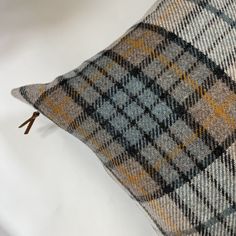 a close up of a plaid pillow on a white surface