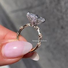 a person holding a ring with a diamond on the inside of it and an image of a frog's head in the middle