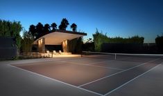 a tennis court at night with the lights on