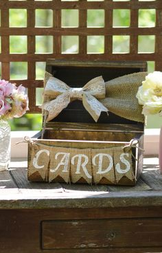 a wooden box with the word cards on it sitting on a table next to flowers