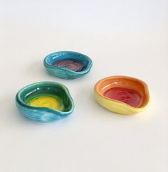 three small bowls with different colors on them