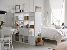 a bedroom with white walls and furniture in it